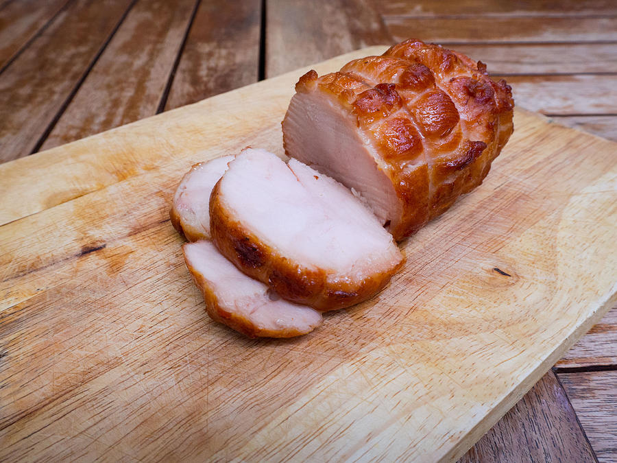 Smoked chicken breast sliced on wooden cutting board Photograph by Lollynut