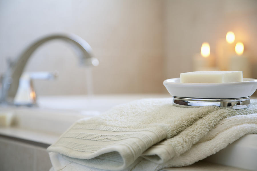 Soap and towels on edge of bathtub Photograph by Tammy Hanratty