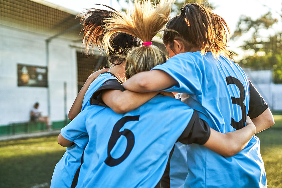 Soccer girls huddling after winning match Photograph by Portra