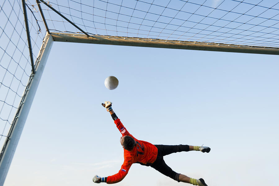 Soccer goalie defending in mid-air Photograph by Technotr