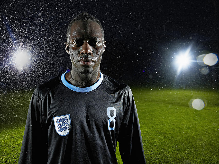 Soccer player standing on field in rainstorm Photograph by Thomas Barwick