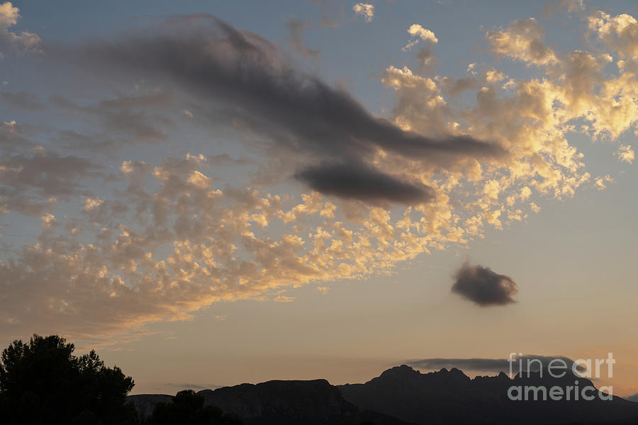 Soft clouds hovering over the Sierra de Bernia mountain range Photograph by Adriana Mueller