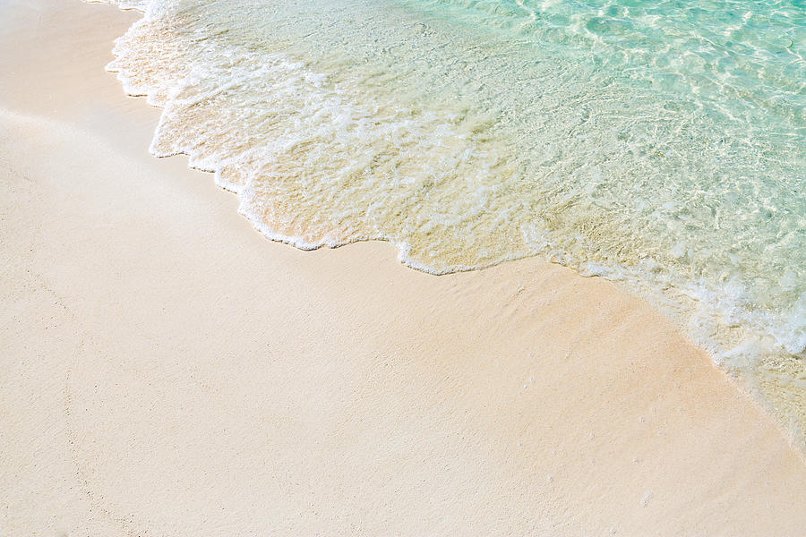 Soft wave of blue ocean on sandy beach. Website background design. Photograph by Levente Bodo
