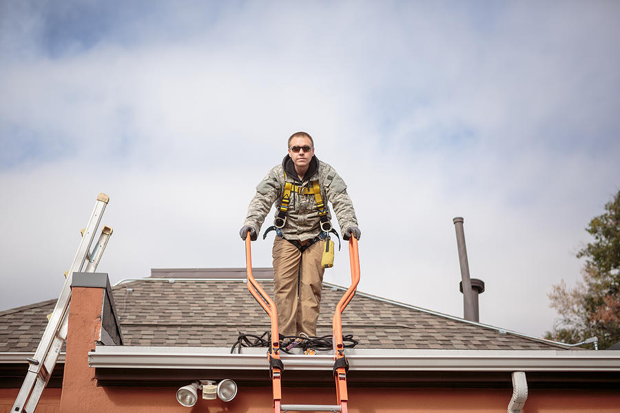 Solar panel installation worker on roof of house Photograph by Heshphoto