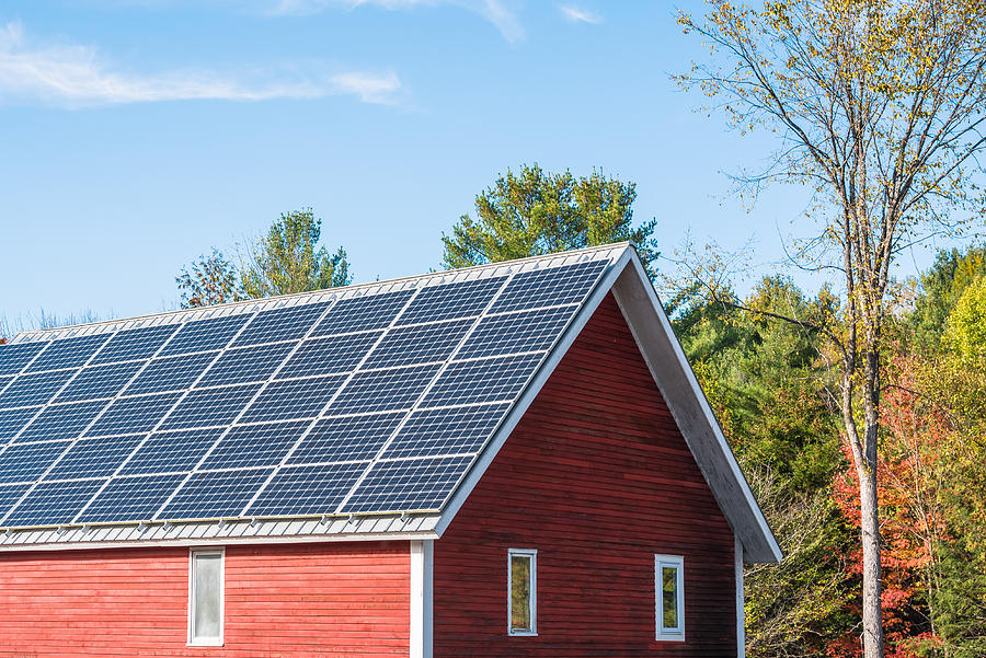 Solar panels on the roof of a farm building on a clear autumn day Photograph by AlbertPego