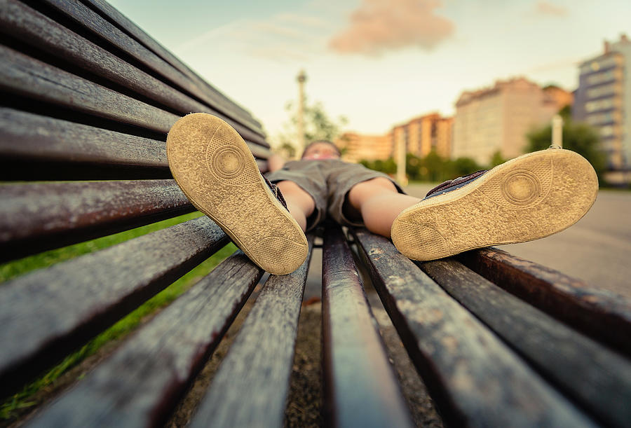 Sole shoes closeup of boy lying on a wooden bench Photograph by Doble.d