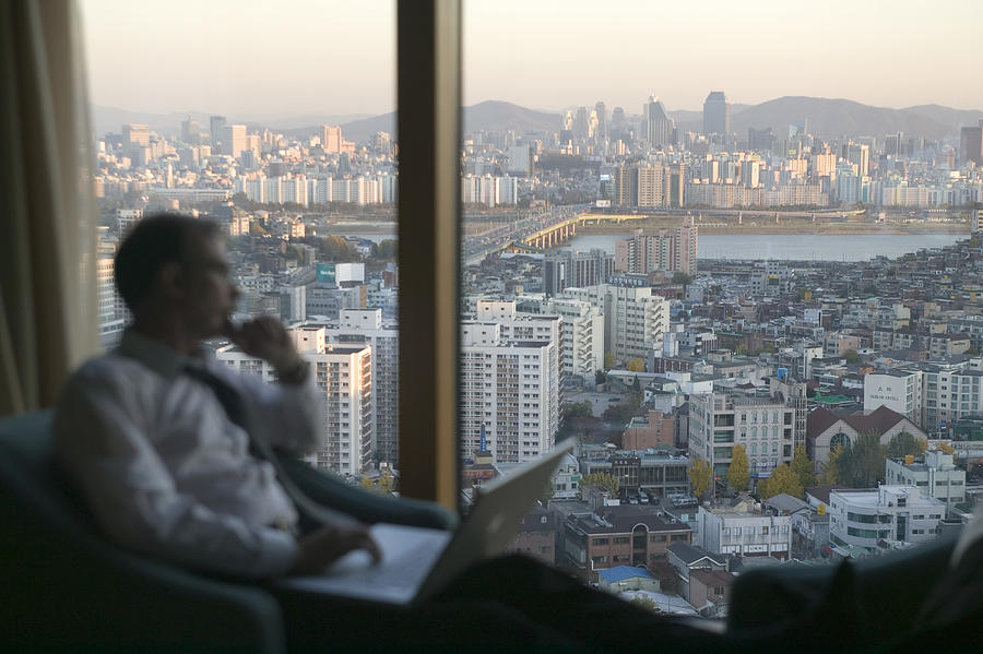 South Korea, Seoul, Kangnam-gu, mature businessman looking out window Photograph by Will & Deni McIntyre