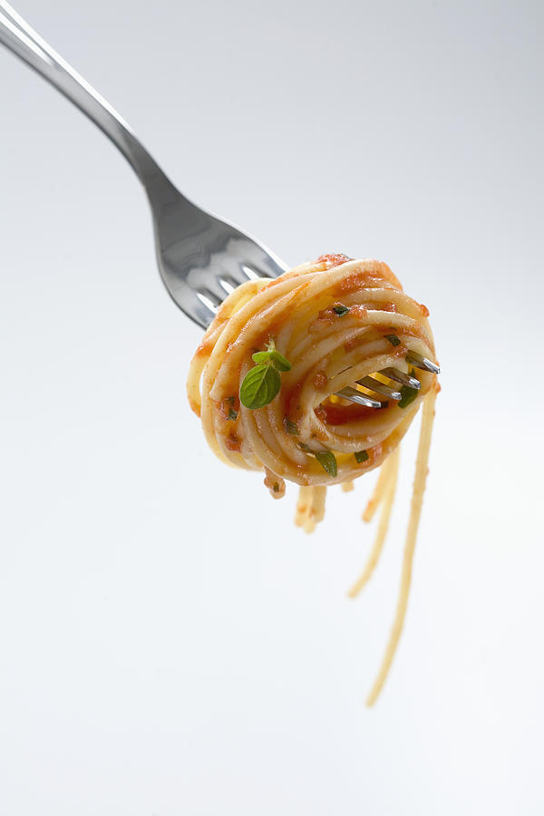 Spaghetti with sauce wound around fork, close-up, studio shot Photograph by John Lund