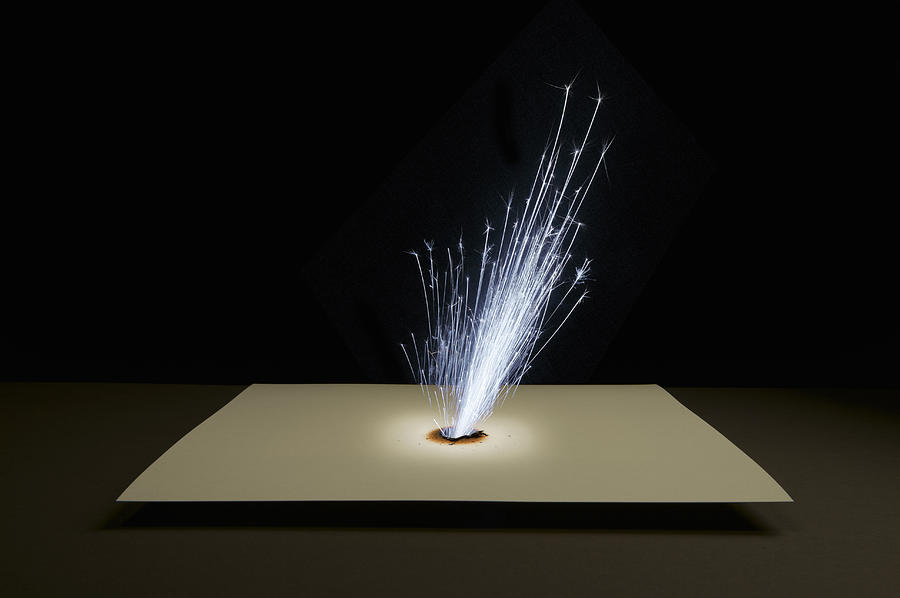 Sparks Shooting Through Paper Photograph by Paul Taylor