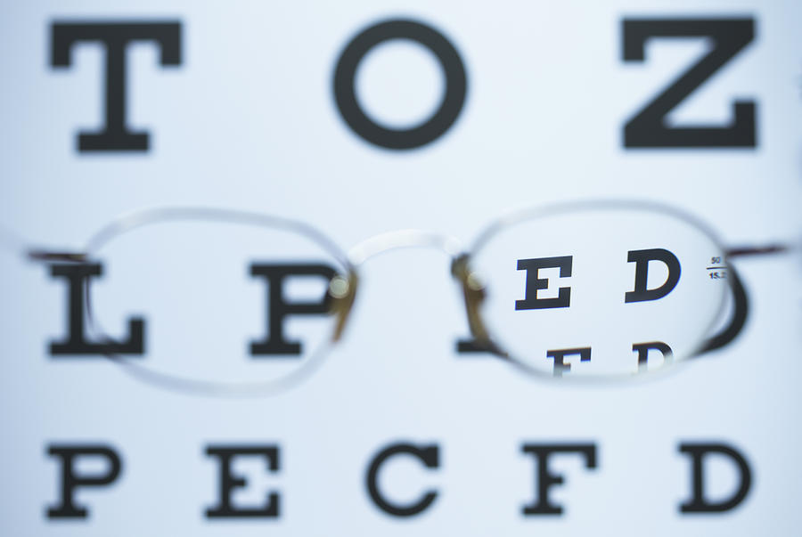 Spectacles with one myopic lens (negative) and the other is missing are used to look at the Snellen eye chart. The image is in focus when looking through the lens Photograph by GIPhotoStock