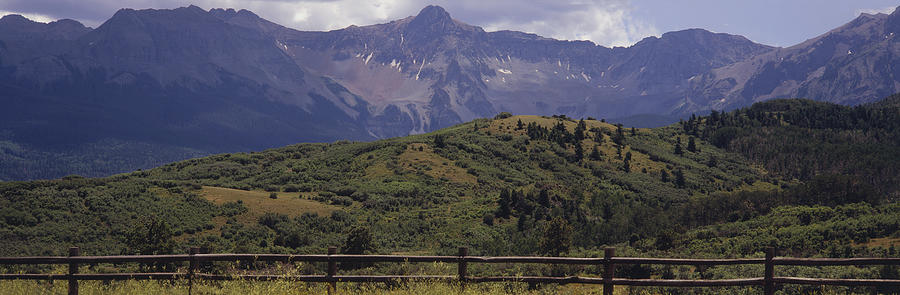 Split rail fencewith Rocky Mountains beyond Photograph by Timothy Hearsum