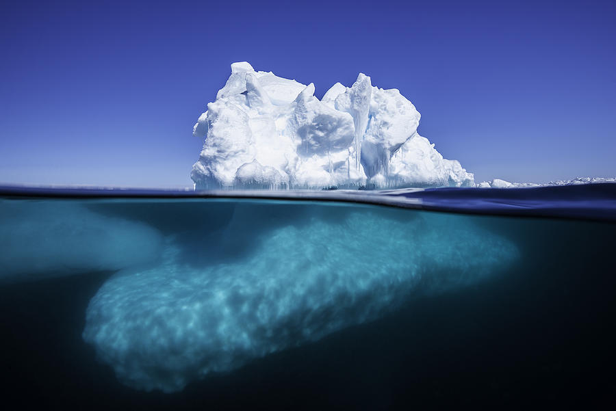 Split view of an iceberg at the ice floe edge showing what is above and below the waterline on a bright sunny summers day in Admiralty Sound, Baffin Island, Canada. Photograph by By Wildestanimal