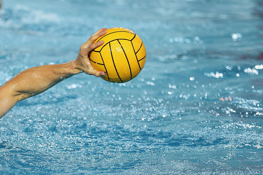 Sportsman Holding a Water Polo Ball above the water Photograph by Elena Popova