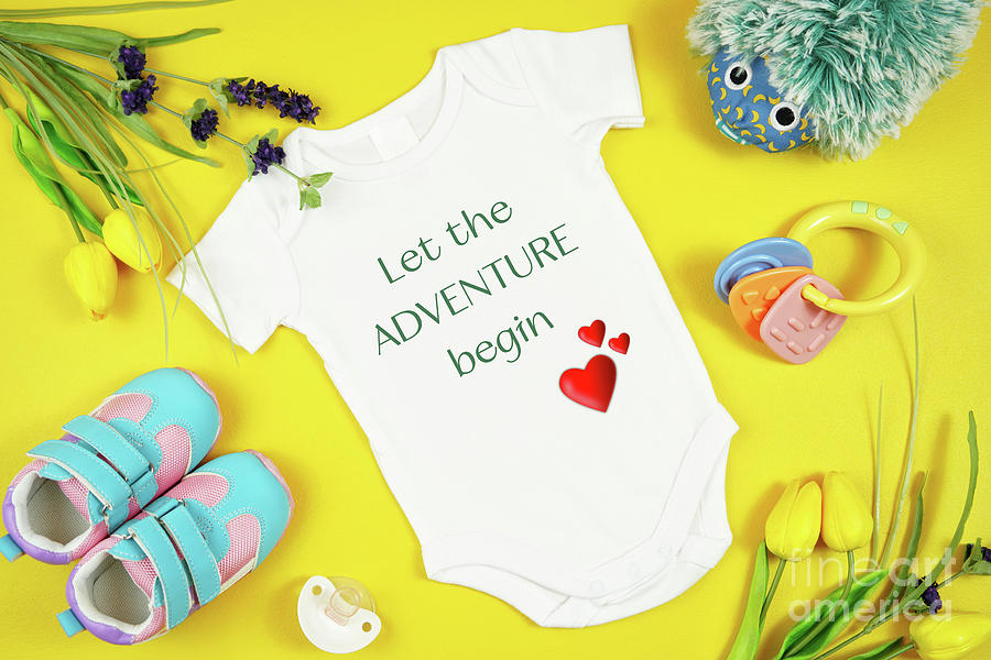 Springtime baby apparel flatlay top view on yellow table. Mock up. Photograph by Milleflore Images