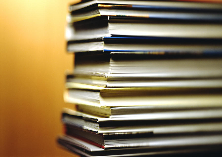 Stack of books, corners in foreground, yellow background Photograph by Christian Zachariasen