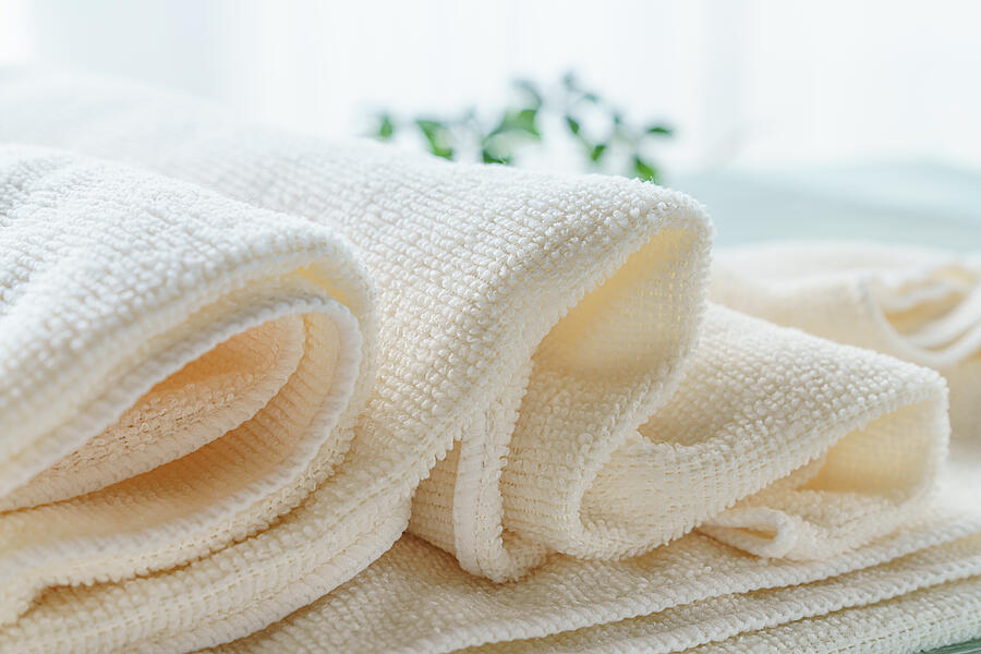 Stack of clean towels on wooden background Photograph by Wako Megumi