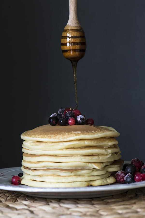 Stack of pancakes with blueberries and honey Photograph by Galyaivanova