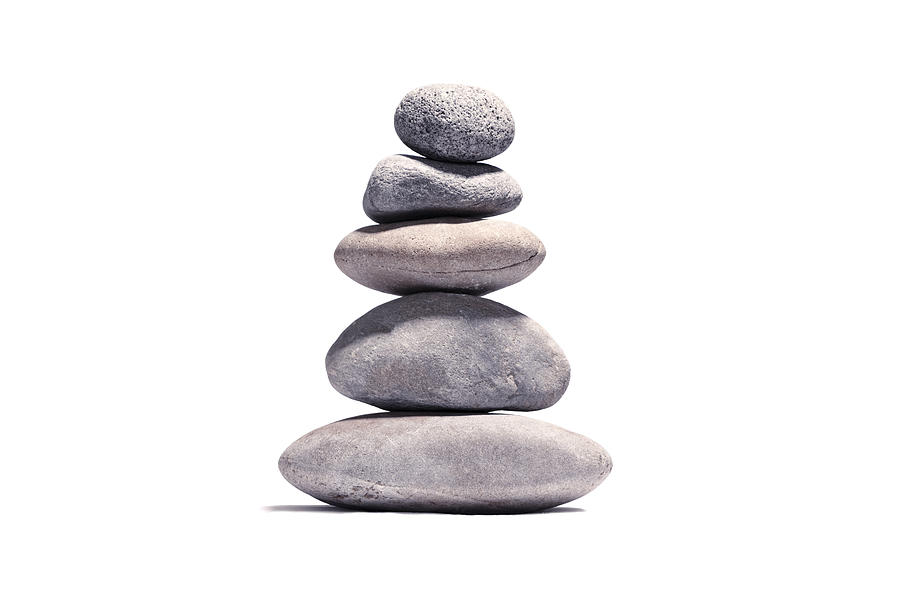Stack of volcanic pebbles isotaded on white with clipping path Photograph by Apomares