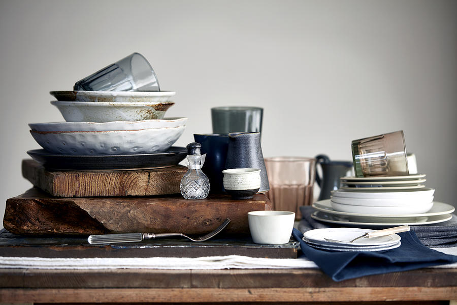 Stacked crockery stacked on cutting board for washing up Photograph by Debby Lewis-Harrison