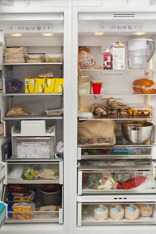 Stacked products in open fridge Photograph by Moodboard
