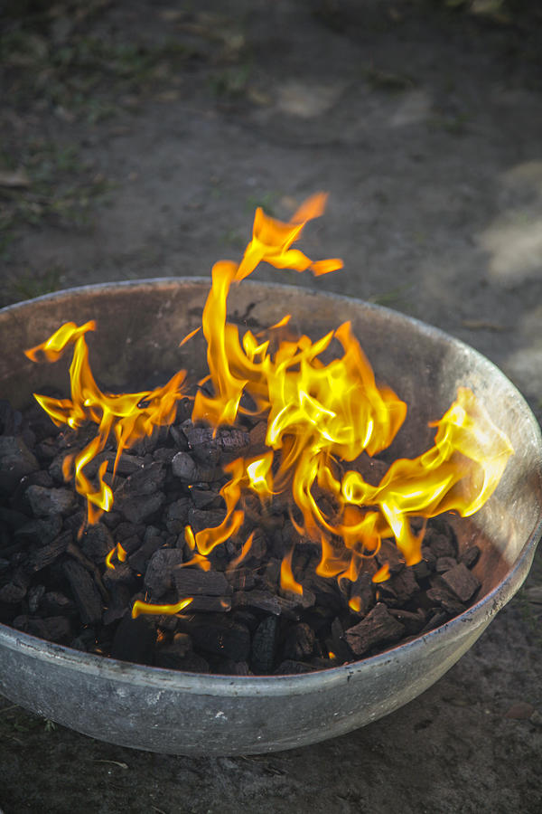 Starting a charcoal fire for grilling. Photograph by Dtimiraos