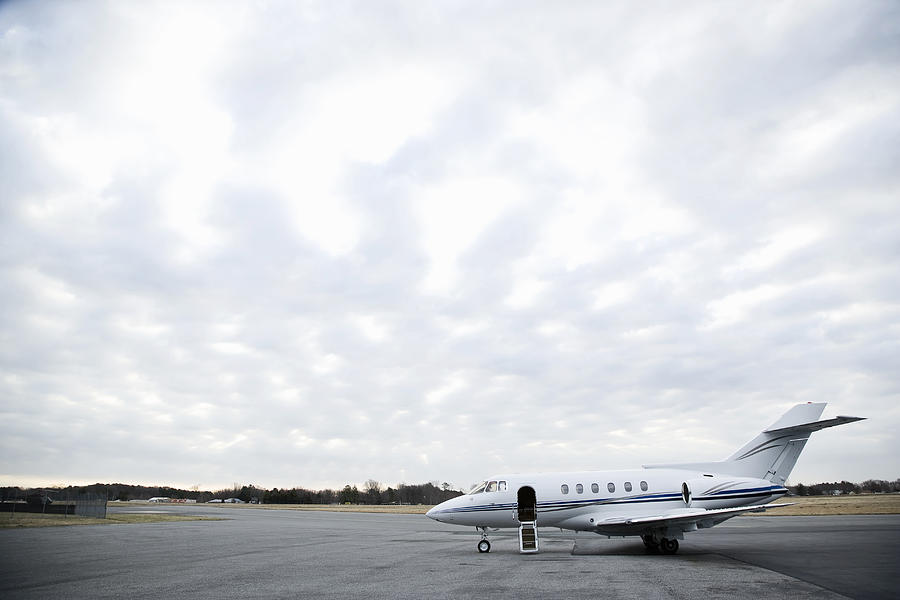 Stationary private jet on airport runway Photograph by Ian Spanier