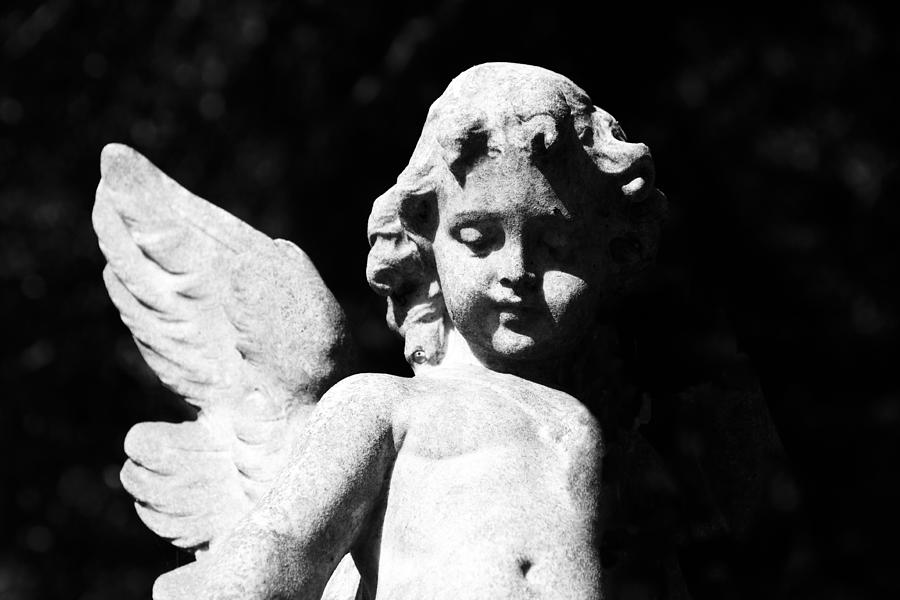 Statue of cherub-angel against black background, copy space Photograph by Imamember