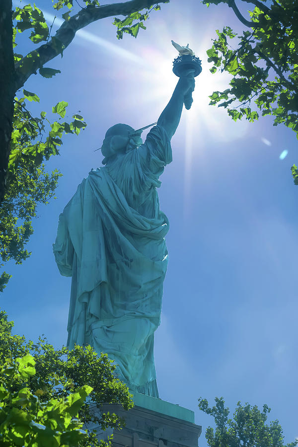 Statue of liberty with sun behind flame.  Photograph by Jean-Luc Farges