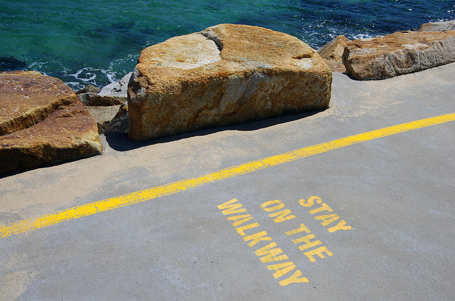 Stay on the Walkway sign stencilled in yellow paint on the concrete walkway of the Southern Break Wall at Coffs Harbour, New South Wales, Australia Photograph by Simon McGill