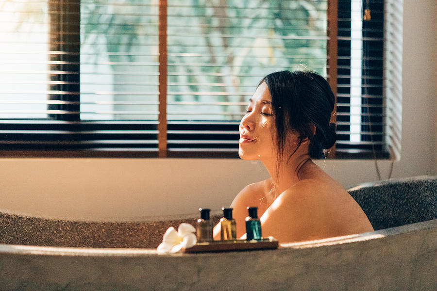 Staycation: young happy woman enjoying in bubble bath in hotel bathroom with her eyes closed Photograph by Oscar Wong