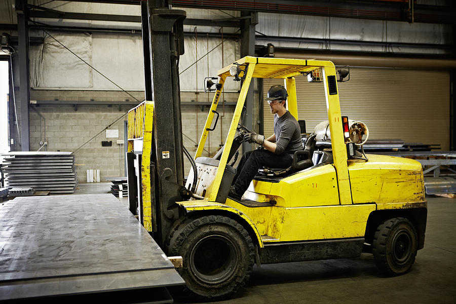 Steel worker driving forklift to move steel Photograph by Thomas Barwick