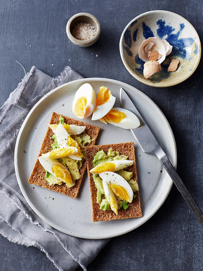 Still life of rye crackers with boiled sliced eggs on plate, overhead view Photograph by Brett Stevens