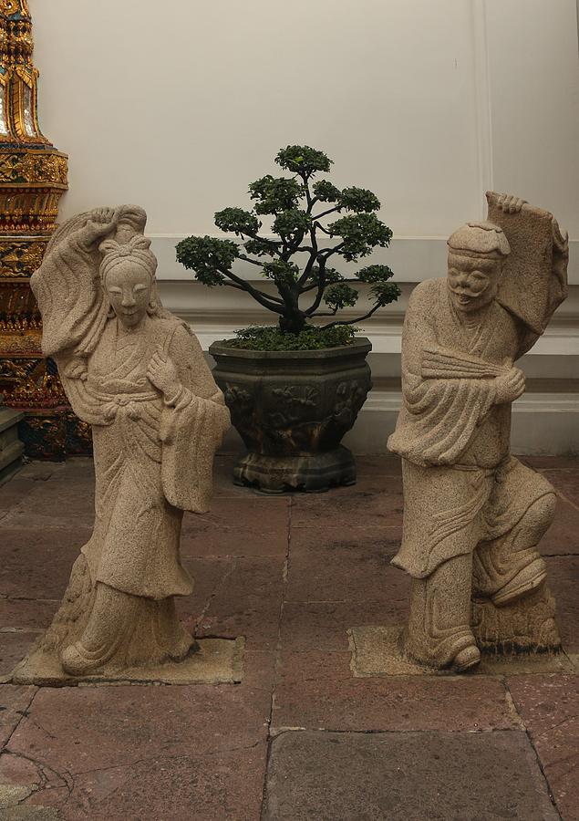 Stone statues from Asian woman and man at a Buddha temple Sculpture by