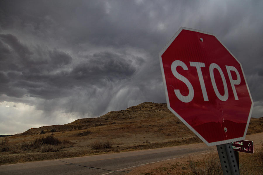 Stop sign and storm clouds at Theodore Roosevelt National Park in North Dakota Photograph by Eldon McGraw