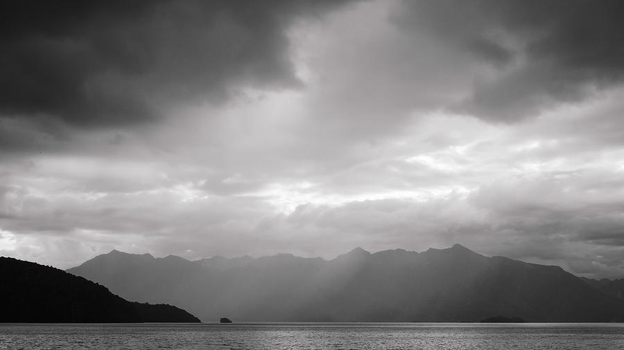 Storm clouds gathering over the lake and mountain range Photograph by Peter Kolejak