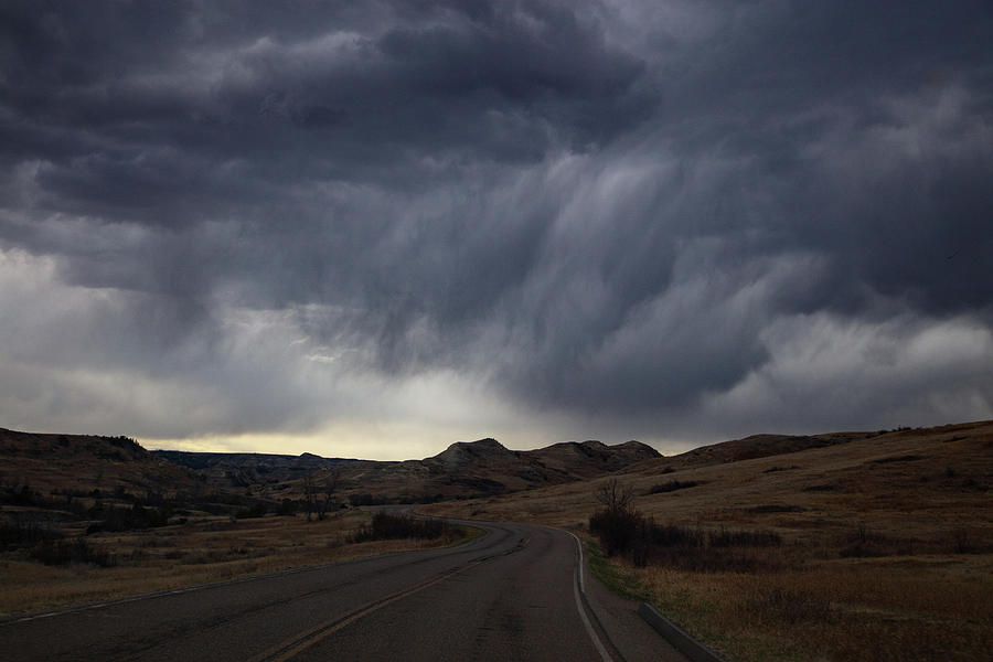 Storm clouds with road at Theodore Roosevelt National Park in North Dakota Photograph by Eldon McGraw
