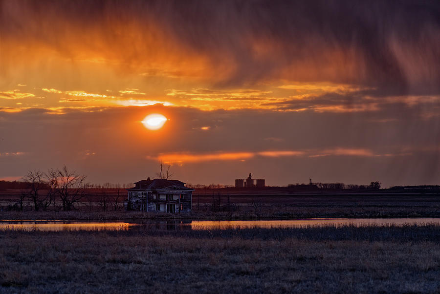 Stormy prairie sunset at a flooded farm home along Devils Lake shore near Churchs Ferry Photograph by Peter Herman