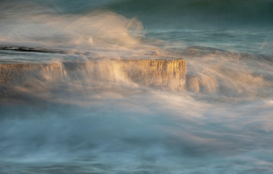 Stormy windy sea waves splashing on a rocky seashore at sunset Photograph by Michalakis Ppalis