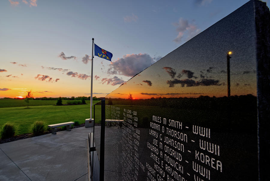 Stoughton Veterans Memorial - sunset reflected in memorial wall stone with VFW flag Photograph by Peter Herman