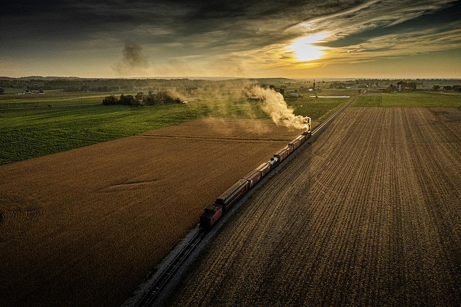 Strasburg Railroad caboose Norfolk Western 475 into the setting sun at Strasburg PA Photograph by Jim Pearson