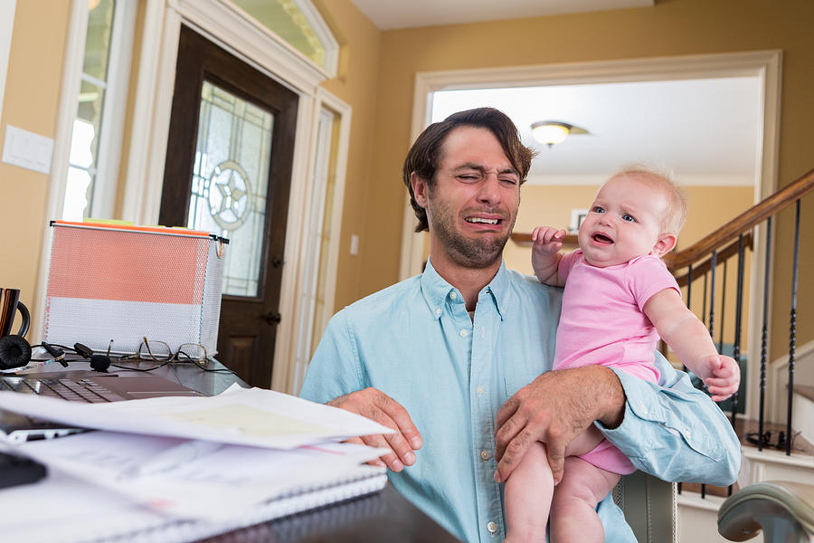 Stressed dad with baby working from home Photograph by SDI Productions