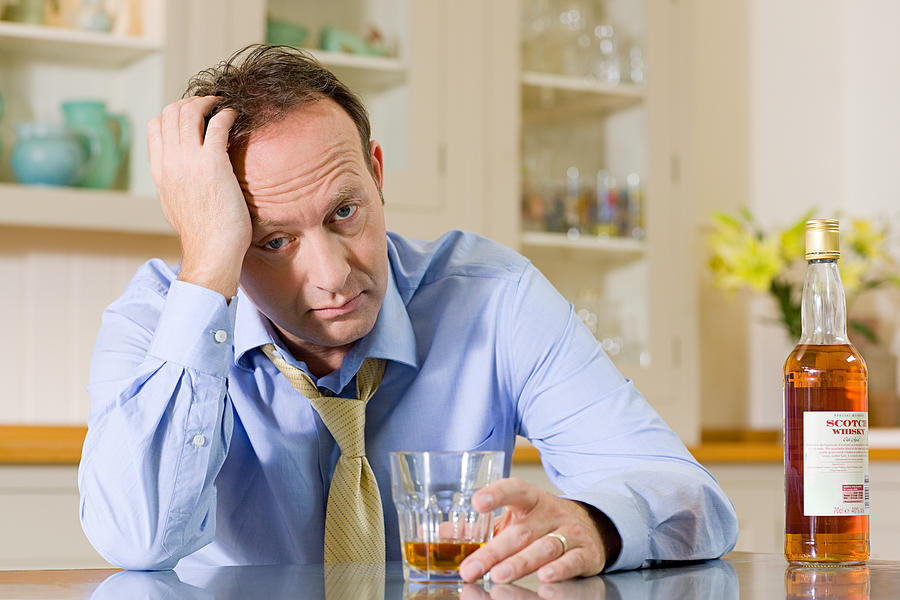 Stressed man with whisky Photograph by Image Source