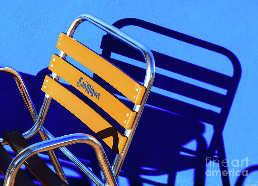 Strong graphic image of San Miguel branded frame chair and sunli Photograph by Peter Noyce