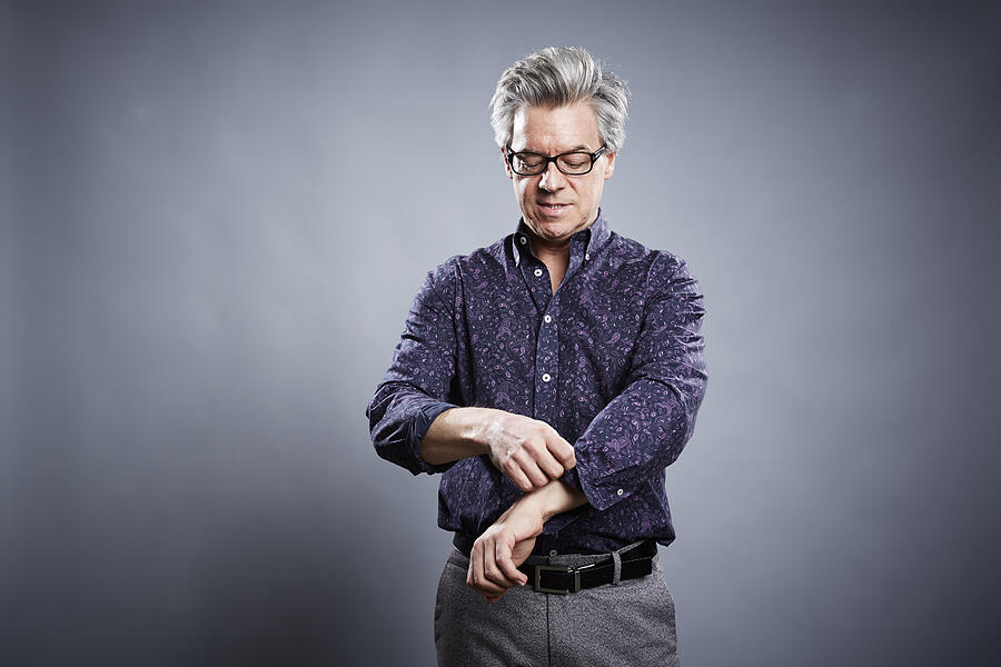 Studio portrait of mature businessman rolling up his sleeves Photograph by Jpm