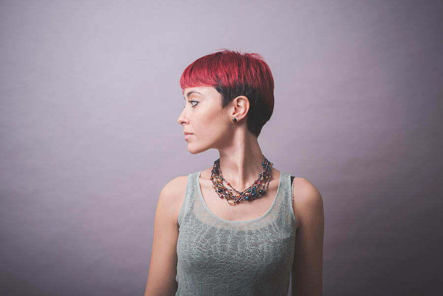 Studio portrait of young woman with short pink hair looking over her shoulder Photograph by Eugenio Marongiu