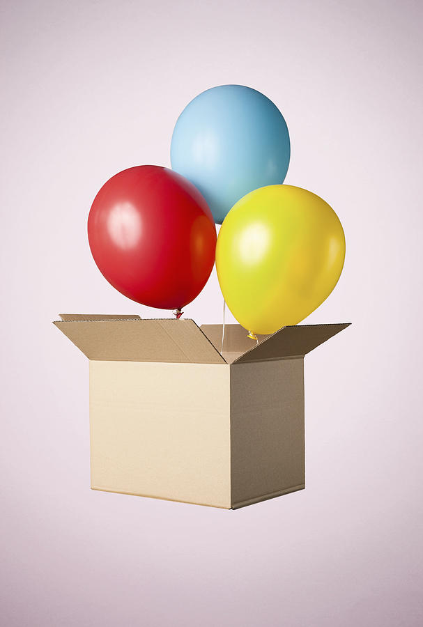 Studio shot of cardboard box with balloons coming out Photograph by Sverre Haugland