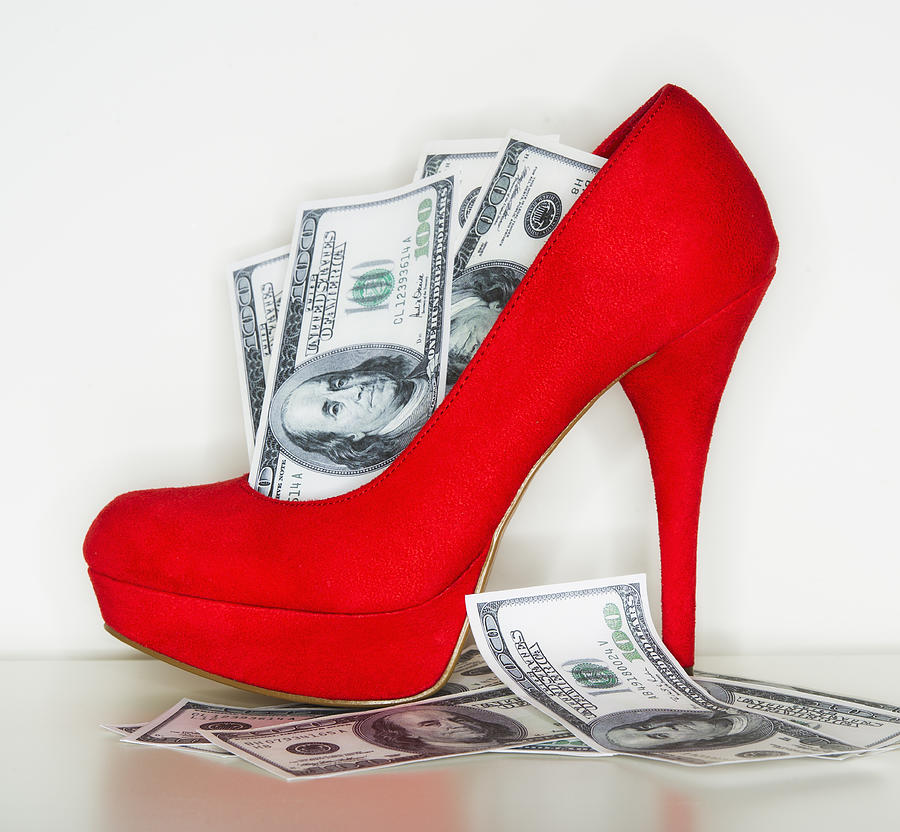 Studio shot of red stiletto and dollar bills Photograph by Tetra Images