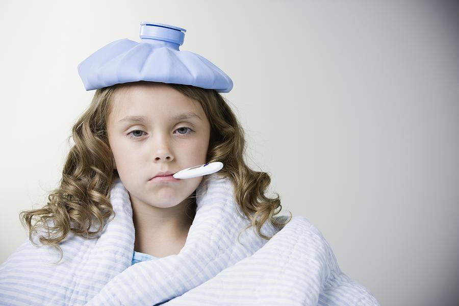Studio shot of sick young girl with thermometer in mouth Photograph by Andersen Ross Photography Inc