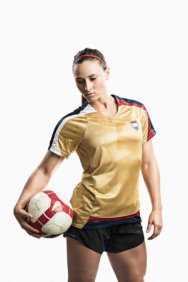 Studio shot of young female soccer player holding ball Photograph by Corey Jenkins