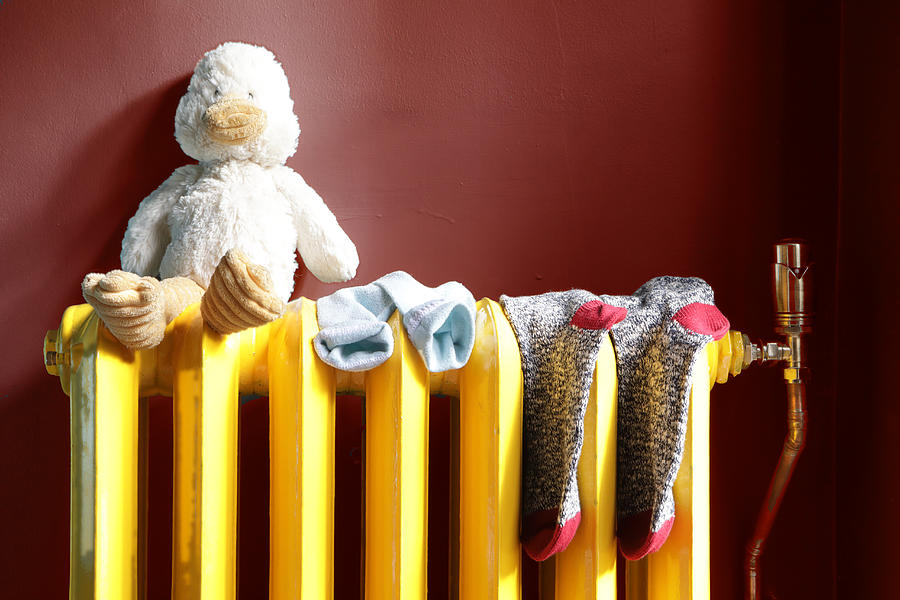 Stuffed Toy And Socks On Radiator Photograph by Peter Cade